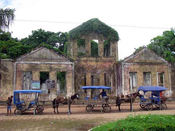 An elegant ruin at the dock in Cotijuba, horsedrawn taxis in front.
