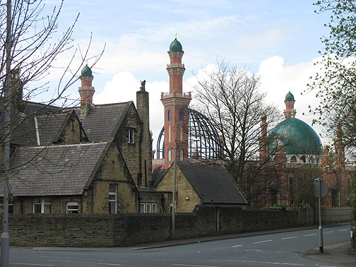 Gleaming new mosque going up behind centuries-old stone houses.