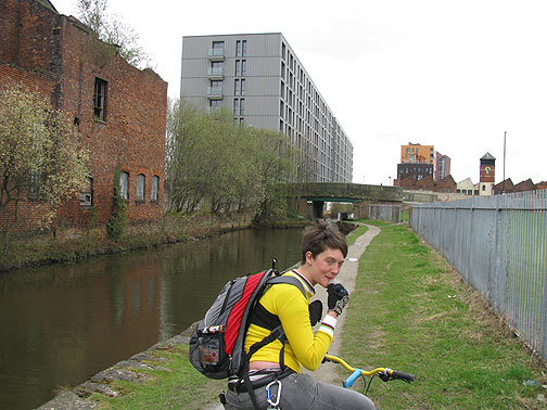 Nes pausing on canal, ruins and new development in distance.