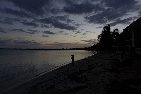 Young girl fishing at sunset, Bay of Pigs.